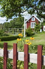 Typical red wooden house, surrounded by a beautiful garden, in the small Swedish coastal town of