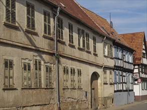 Old buildings and half-timbered houses along a sunny street with weathered shutters, Kandel,