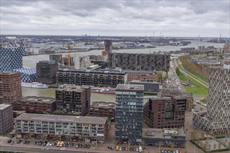 View over a city with numerous buildings and a river flowing through a harbour area, Rotterdam,