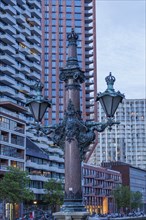 A magnificent lamppost in front of modern buildings at dusk, rotterdam, the netherlands