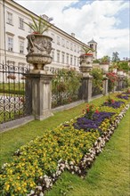 A well-tended park with flower beds in front of a historic building, gosau, alps, austria