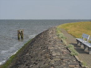 A stone path leads along the coast, lined by a bench, hallig hooge, schleswig-holstein, germany