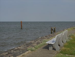 Benches along a stone path on the seashore, hallig hooge, schleswig-holstein, germany
