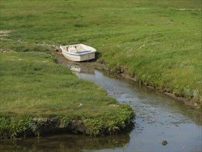 Small boat in a quiet creek, surrounded by grass and nature, hallig hooge, schleswig-holstein,