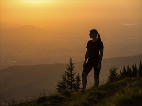 Silhouette of a young slender woman on a mountain meadow in the evening light, Schlenken, Bad