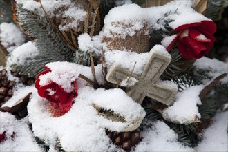 A memorial with a crucifix and flowers in winter A memorial with a crucifix and flowers in winter