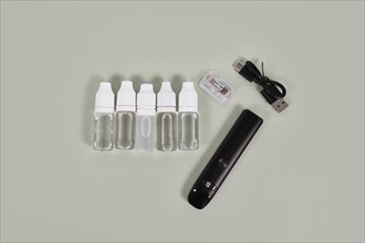 Bottles with liquid solutions for electronic cigarettes and charger