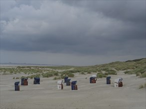 Several beach chairs on a sandy beach under a cloudy sky, Juist, North Sea, Germany, Europe