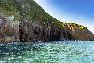 Rocky cliff over the sea on the island of Ilhabela in Sao Paulo at sunset, Ilhabela, Sao Paulo,