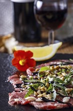 Fresh carpaccio with rocket on slate