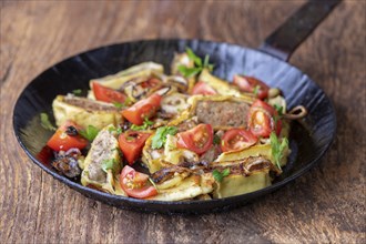 Swabian dumplings with onions in an iron pan