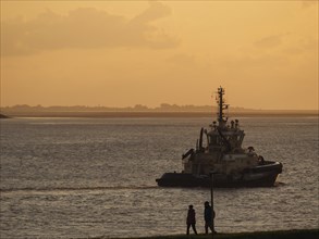 Evening silhouette of a ship on the water in front of a picturesque sunset, bremerhaven, bremen,