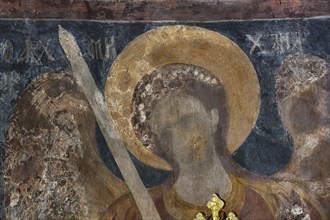 Wall painting of an angel with halo and sword in a church, weathered and damaged, Byzantine chapel