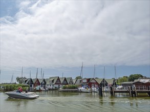 Harbour with many boats and red houses, marina atmosphere under clouds, ahrenshoop, zingst, germany