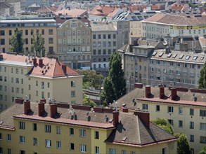 View of a city with various buildings, red roofs and chimneys on a sunny day, Vienna, Austria,
