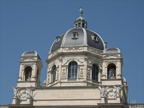 Close-up of a baroque building with a detailed dome and towers under a clear sky, Vienna, Austria,