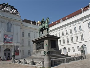 Monument of an equestrian statue on a pedestal in front of a baroque building, Vienna, Austria,