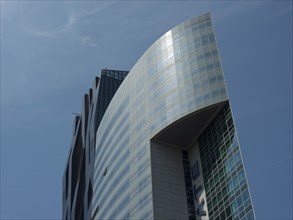Facade of a modern, curved skyscraper with glass front against a blue sky, Vienna, Austria, Europe