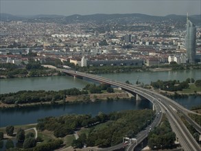 Expansive city view with rivers, bridges and mountains visible in the background, Vienna, Austria,