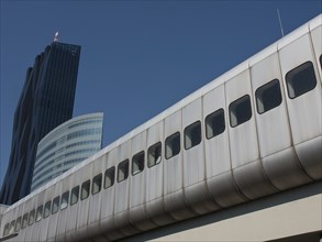 Modern high-rise building next to an elevated railway line under a blue sky, Vienna, Austria,