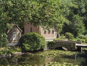Rural idyll with a pond full of water lilies and a charming stone bridge flanked by old brick