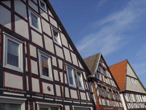 Row of traditional half-timbered houses with different roof shapes under a clear blue sky, Waldeck,