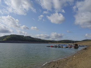 Quiet lake landscape with boats on the shore and hills in the background in fine weather, Waldeck,