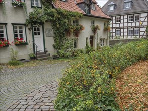 Historic houses with flowers on the windows and cobbled street, Werl, North Rhine-Westphalia,