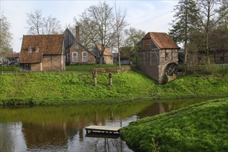 Idyllic landscape with traditional farmhouses and green lawns by a stream, Vreden, North