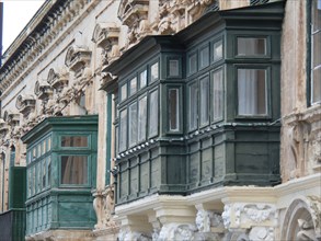 Detailed wooden balconies on a historic building with ornate facades, valetta, mediterranean sea,