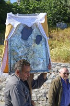 Man carrying a religious icon during a procession, Procession of the icon Panagia Skiadni from