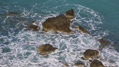 Rocks in the sea, surrounded by spray and surging waves, Atavyros beach, near Monolithos village,