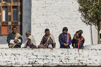 Bhutanese people in traditional clothes watching the annual Tsechu of Trongsa Dzong, Bhutan, Asia