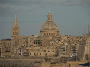 Urban landscape with historic buildings, a large dome and a tower, in the sky, valetta,