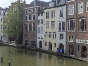 Row of historic townhouses along a canal on a quiet day, utrecht, Netherlands