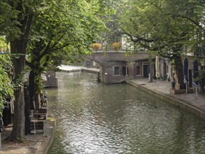 Quiet canal surrounded by trees and buildings, a relaxed summer atmosphere, utrecht, Netherlands