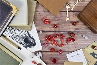 Tabletop role playing flat lay background with red RPG dices, rule books and notes on wooden