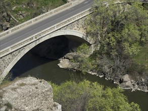 Stone bridge over a river with neighbouring trees and rocks, Toledo, Spain, Europe