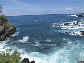 View of the vast ocean with turquoise-coloured waves crashing against a rocky coastline