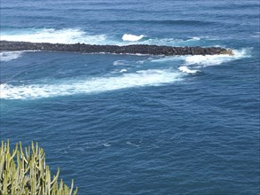 Close-up of a coastal area with strong waves and blue sea water, Puerto de la cruz, tenerife, spain