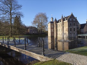 Historic castle with moat and bridge, surrounded by trees and clear blue sky, ruurlo, gelderland,