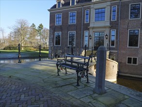 Bench in front of the entrance area of a historic castle, with cobblestones and a quiet atmosphere,