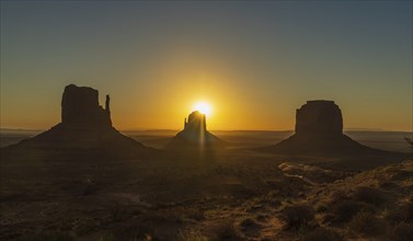 Sun rising behind a butte at Monument Valley, Navajo Nation