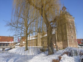 Castle in winter, next to a large willow tree, surrounded by snow and a clear blue sky, Raesfeld,