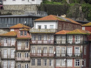 Close-up of building facades with red tiled roofs and numerous windows in a historic city, Porto,