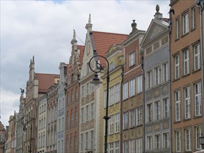 Row of colourful and artistic facades of historic buildings under a cloudy sky, Gdansk, Poland,