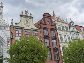 Colourful and artistic facades of historic buildings under a cloudy sky in a city, Gdansk, Poland,