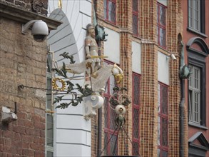 A decorative façade with a statue of an angel and colourful windows on an old building, Gdansk,