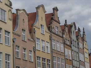 Historic buildings with ornate facades under a cloudy sky, Gdansk, Poland, Europe