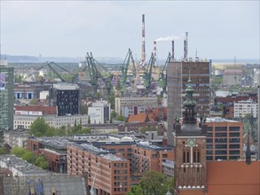 City view with modern buildings, a high tower and cranes in the background, Gdansk, Poland, Europe